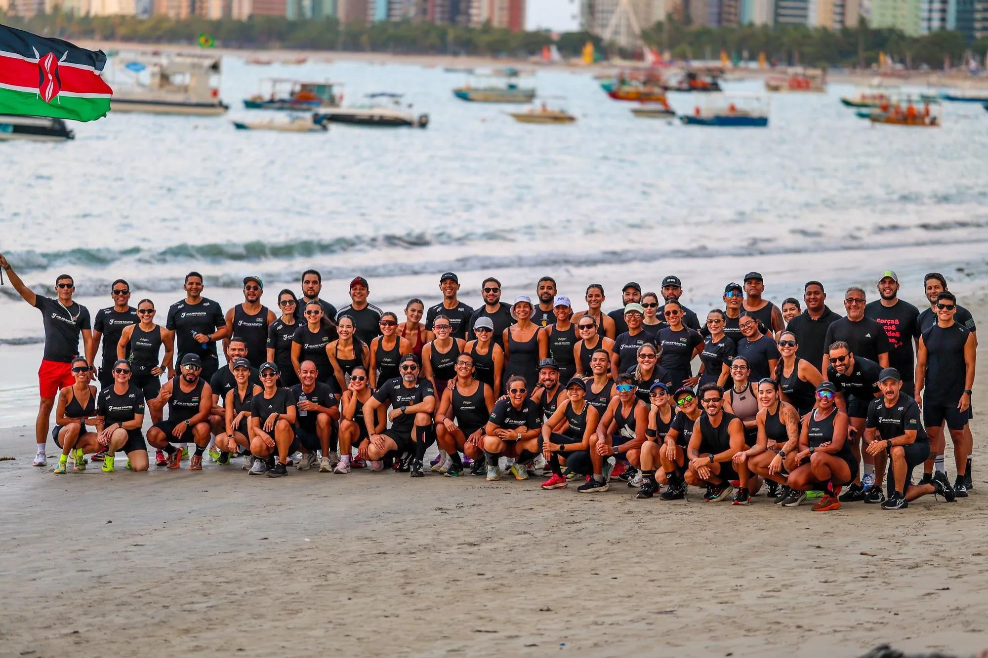Equipe da Assessoria Joaze Santos reunida na praia de Maceió com a bandeira do Quênia
